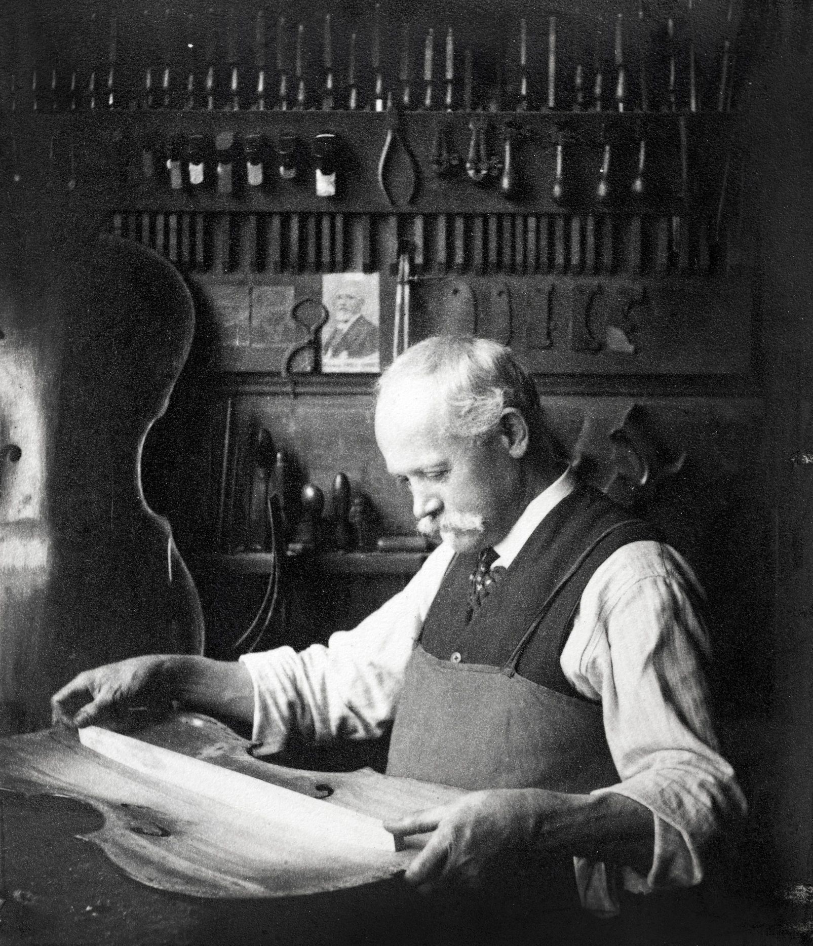 Historic luthier crafting a string instrument in a workshop